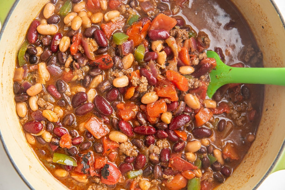 Horizontal image of a big pot of turkey chili, ready to bring to a boil and cook.