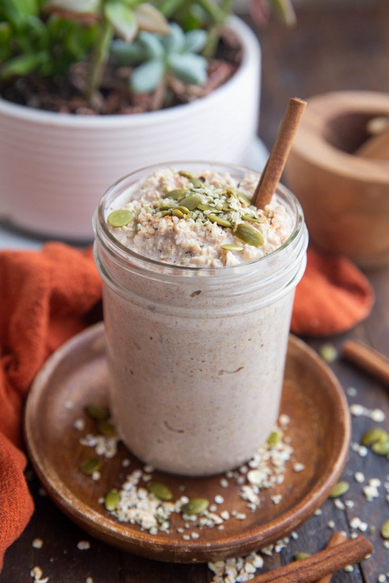 Jar of overnight oats with a pot of succulents in the background.