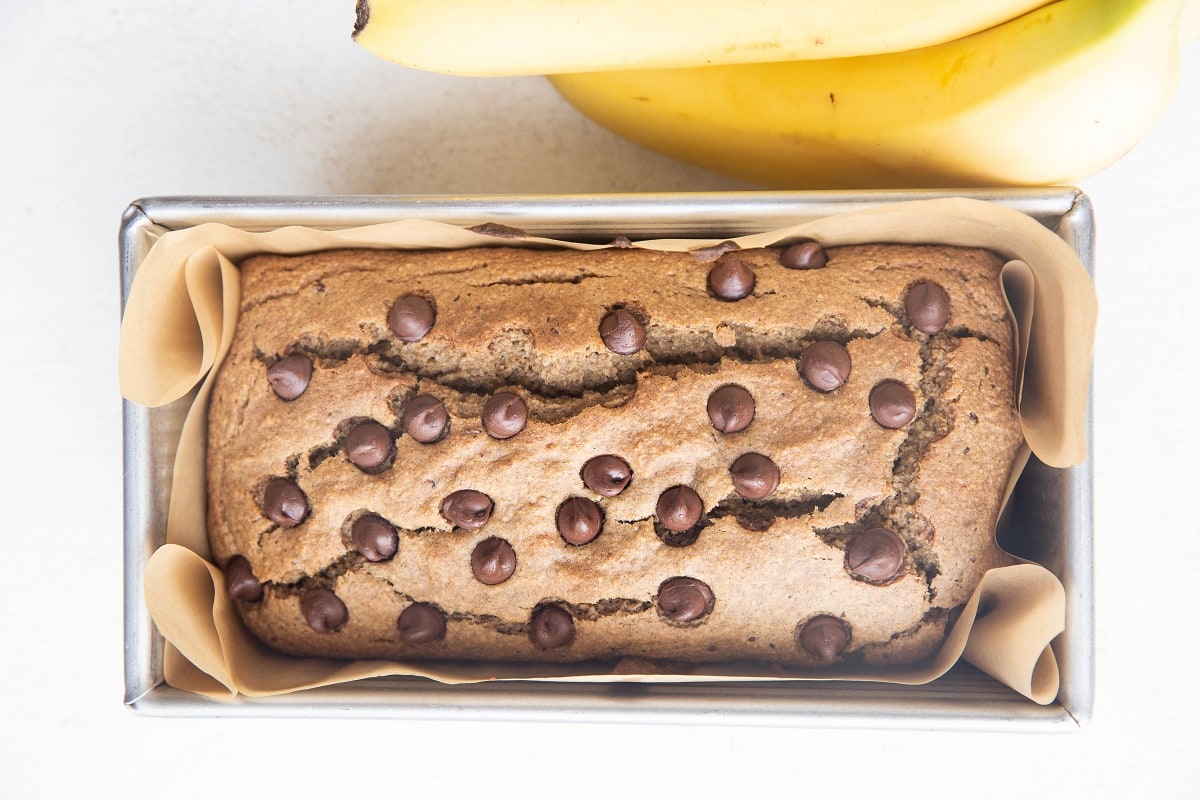 Horizontal image of vegan banana bread fresh out of the oven in a bread loaf pan.