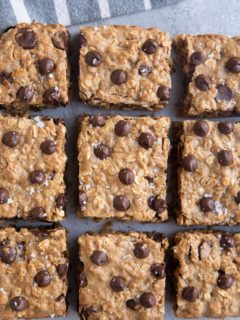 Cookie bars on a grey background with a striped napkin.