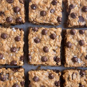 Cookie bars on a grey background with a striped napkin.