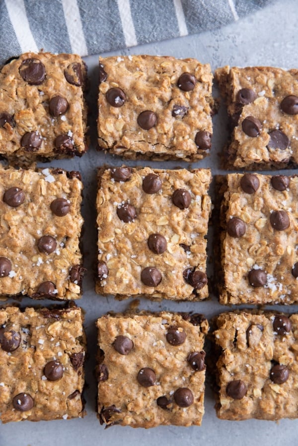 Cookie bars on a grey background with a striped napkin.