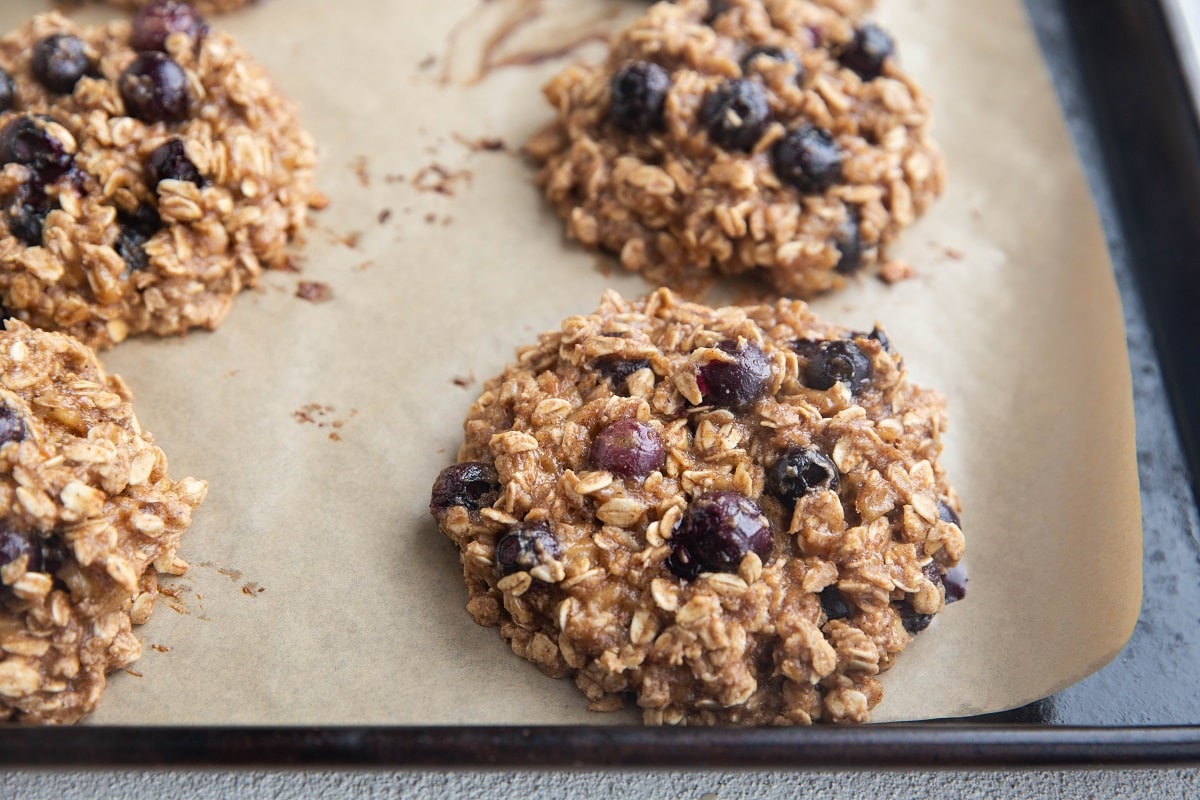 Raw blueberry oatmeal cookie dough on a prepared cookie sheet, ready to go into the oven.