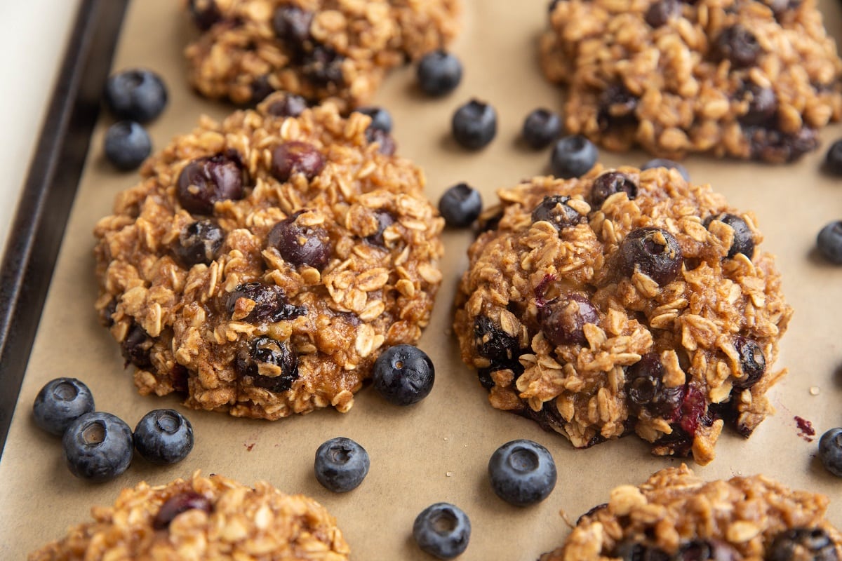 blueberry oatmeal cookies on a parchment lined baking sheet fresh out of the oven.