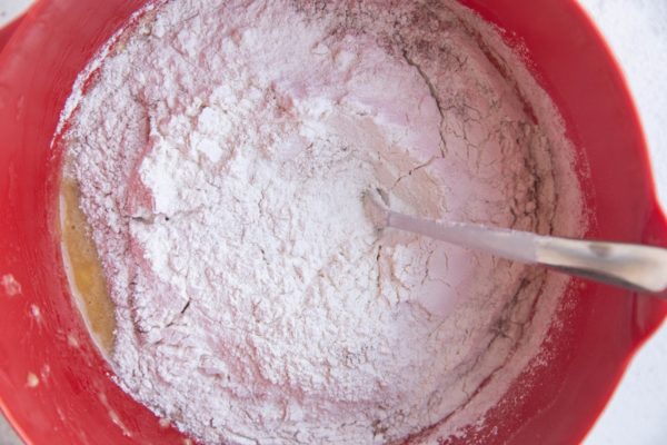 dry ingredients in a large bowl with wet ingredients, ready to be mixed for banana bread batter.