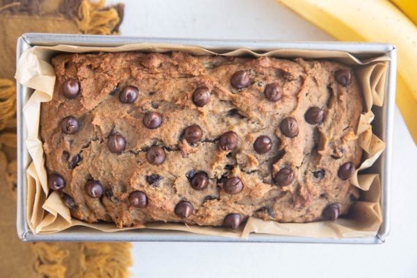 Loaf of banana bread in a bread pan, fresh out of the oven.