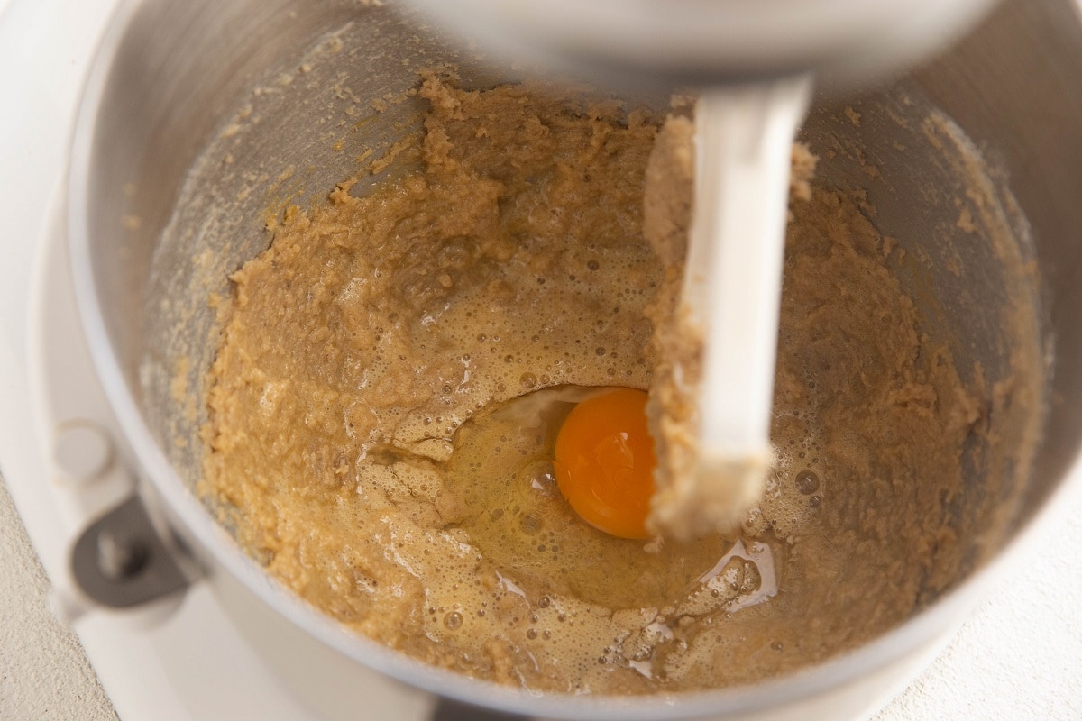 Butter and sugar mixed together in a mixer with eggs being added in.