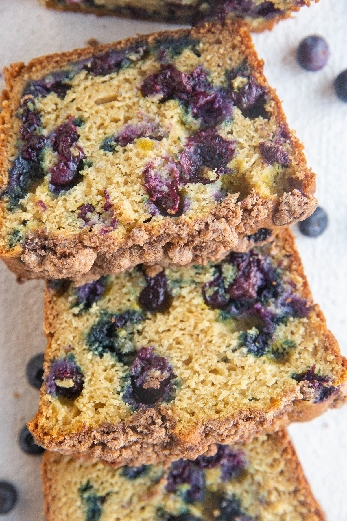 Close up top down shot of slices of blueberry bread on top of each other.