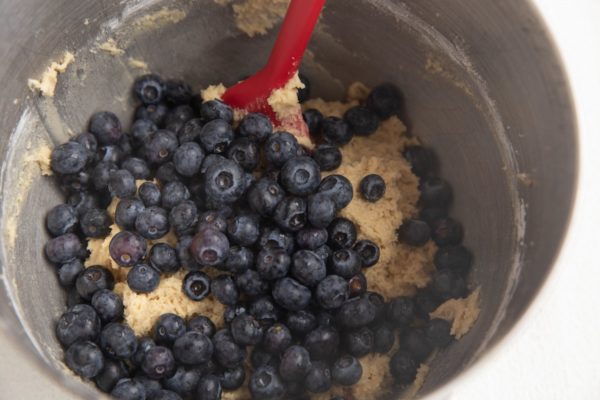 Blueberries on top of the dough, ready to be mixed in.