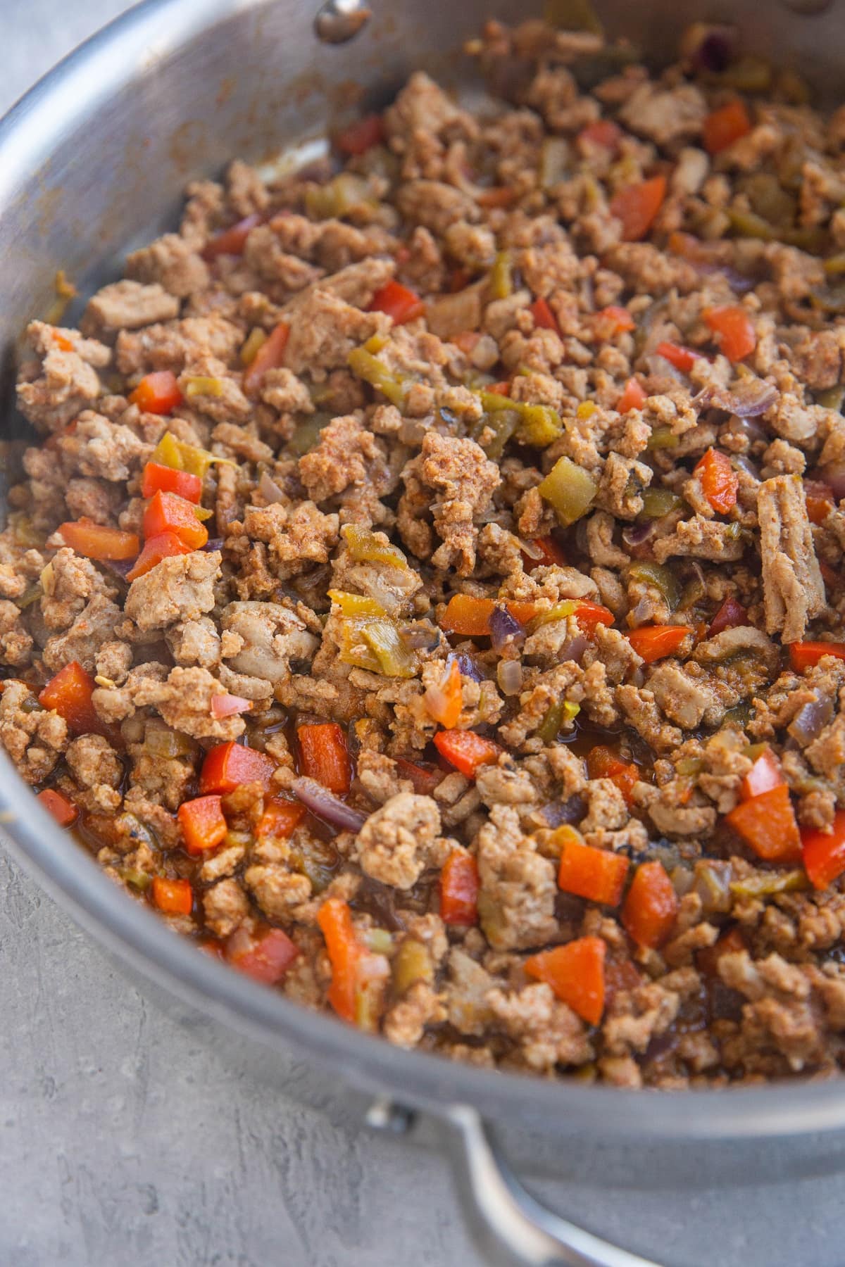 Stainless steel skillet with ground turkey taco meat, ready to be made into tacos.