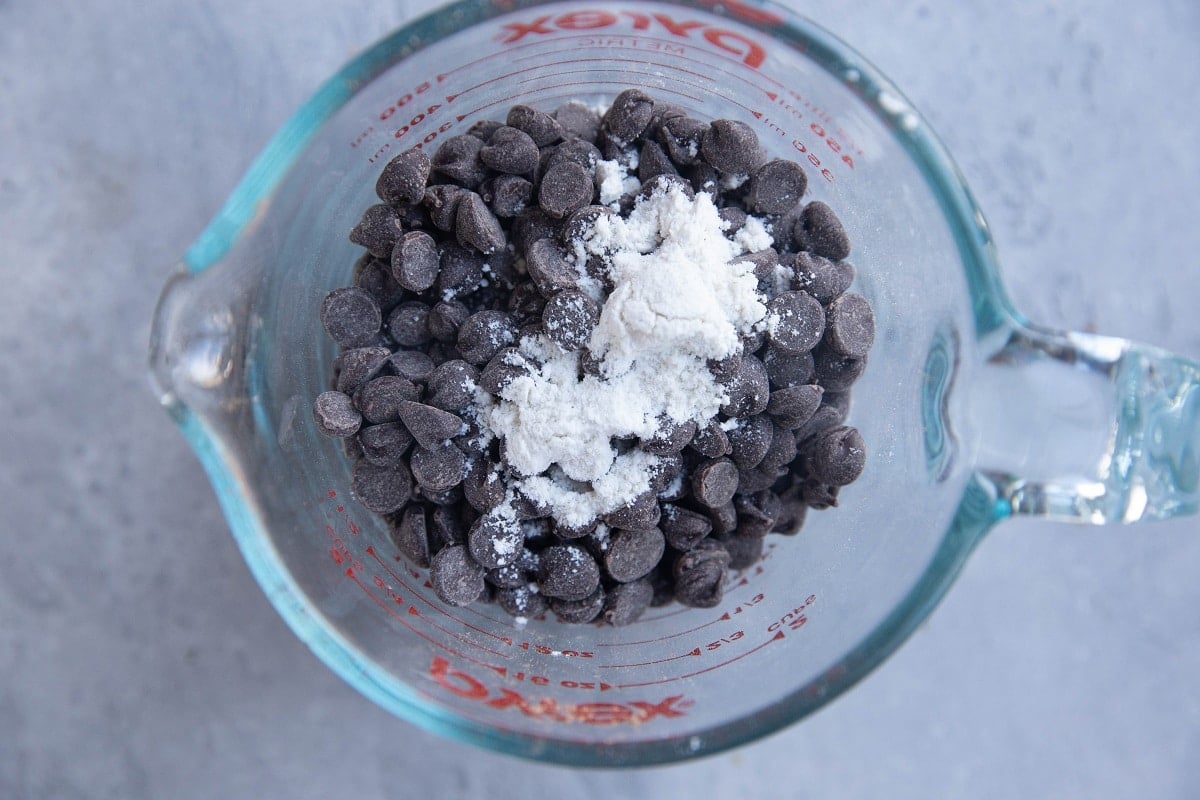 Chocolate chips with flour on top in a measuring cup.