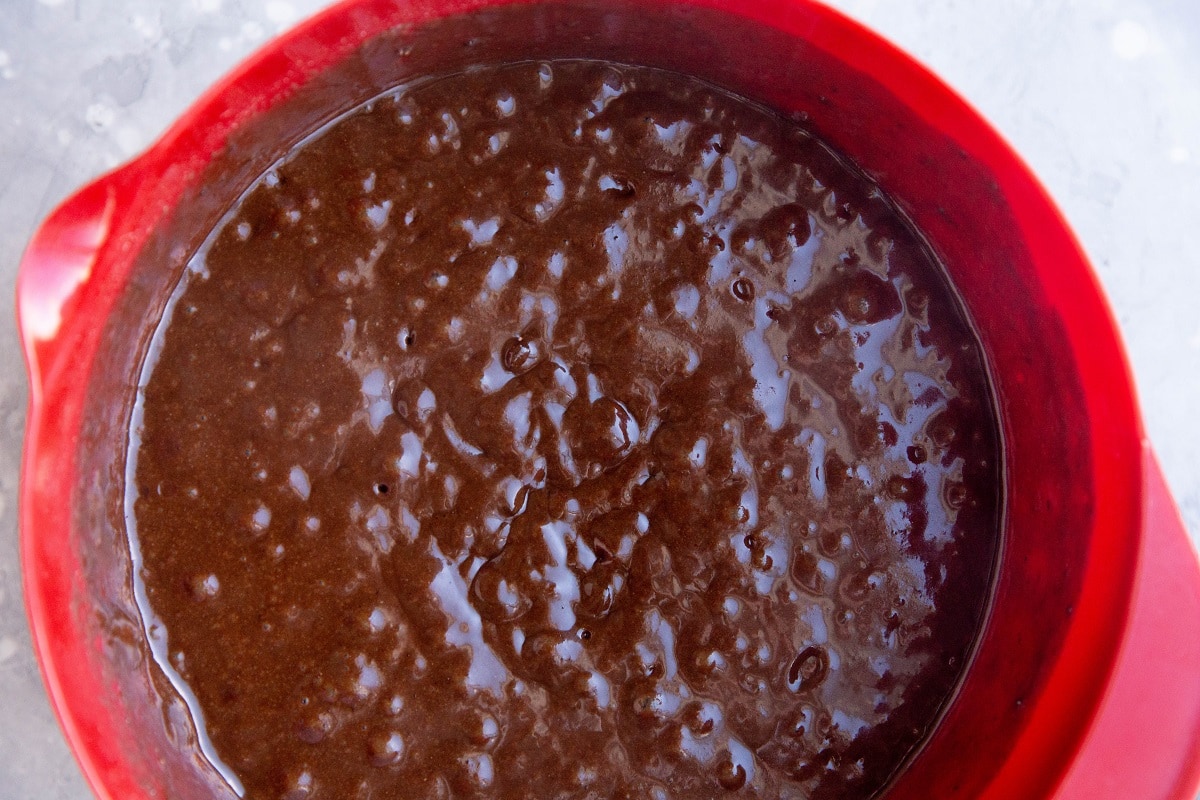Chocolate cake batter in a mixing bowl, ready to be baked.