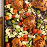 Large sheet pan with crispy chicken and vegetables, ready to be served.