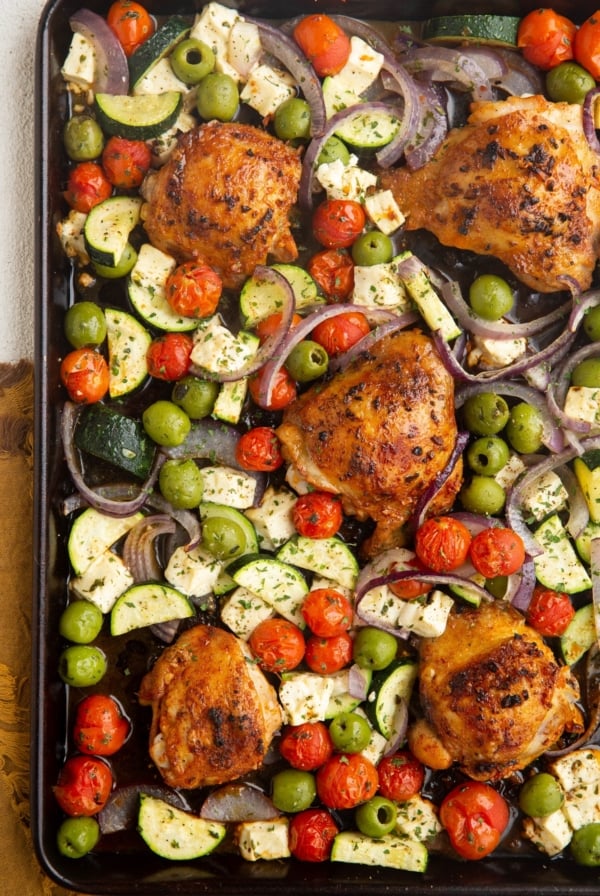 Large sheet pan with crispy chicken and vegetables, ready to be served.