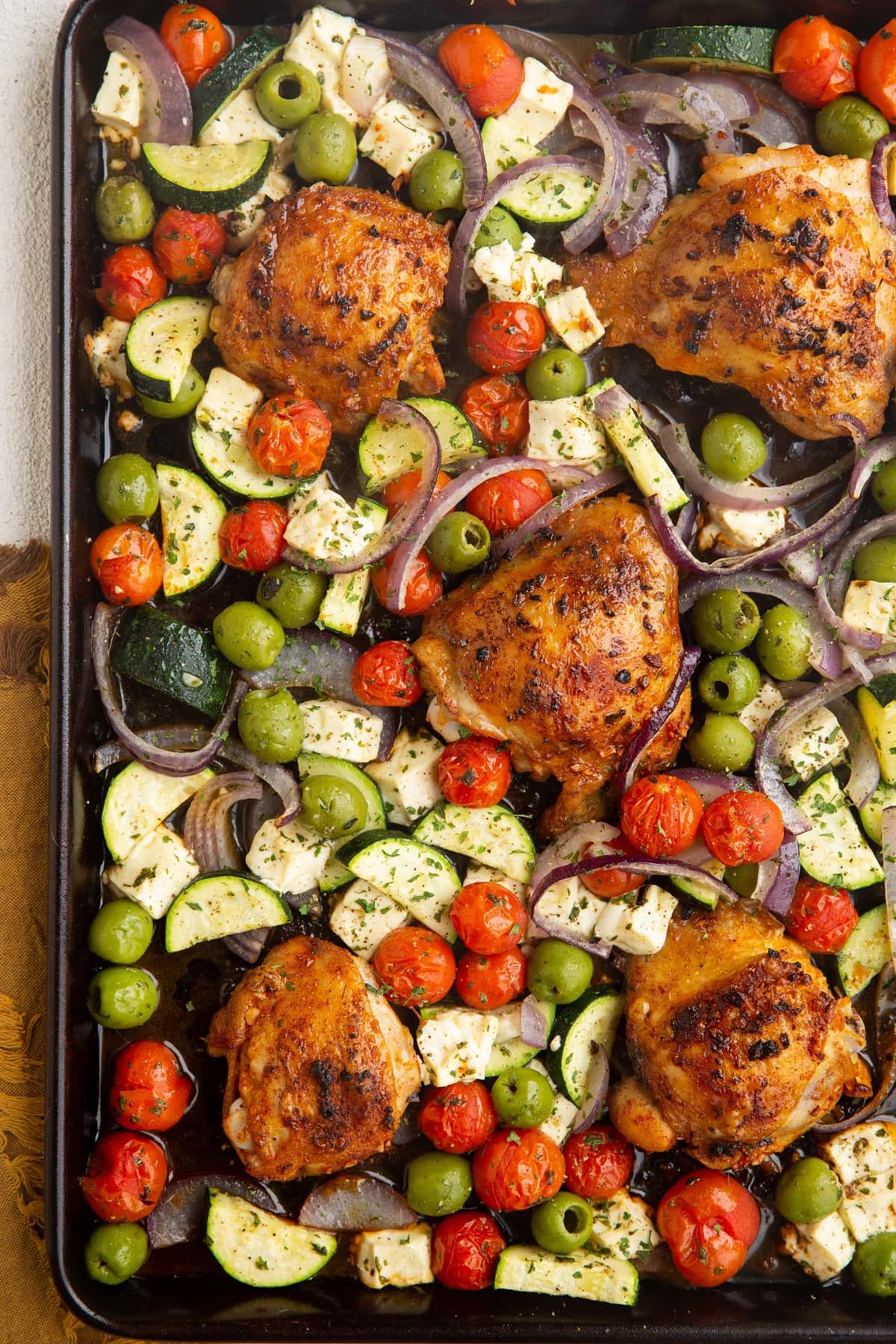 Large sheet pan with crispy chicken and vegetables, ready to be served.