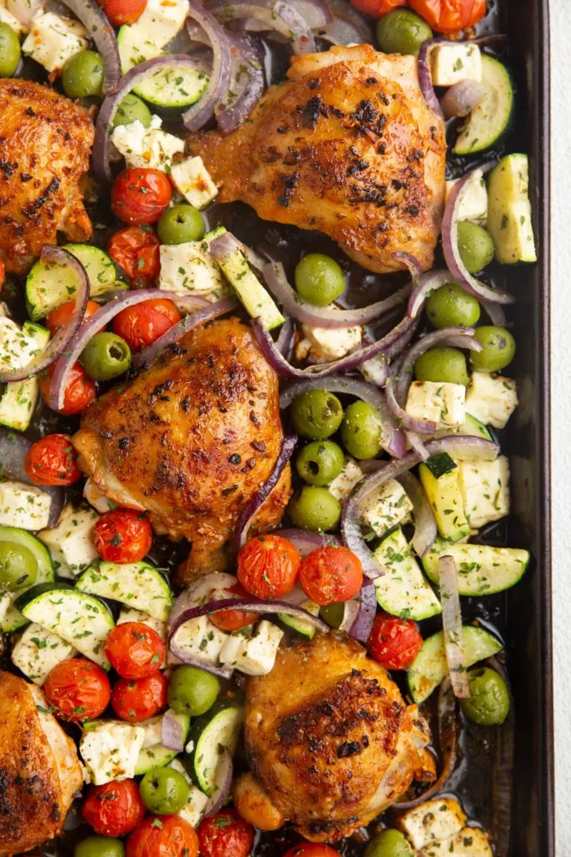 Cooked chicken thighs and vegetables on a sheet pan, ready to enjoy.