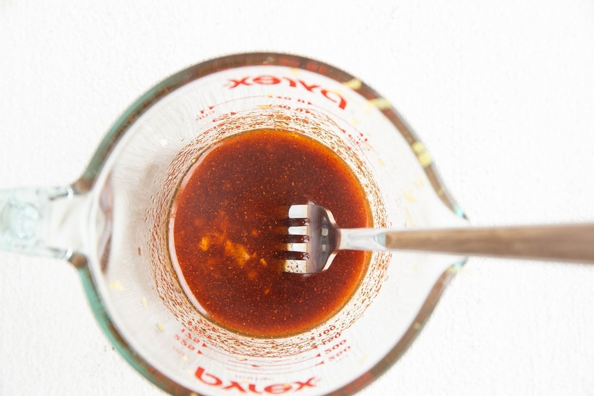 Citrus garlic marinade in a measuring cup for Mediterranean chicken