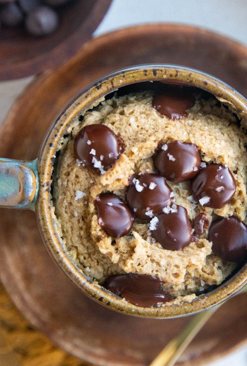 Close up of a finished oatmeal banana mug cake with melted chocolate chips on top.