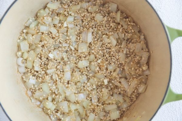 Rice, onion and garlic cooking in a stock pot.