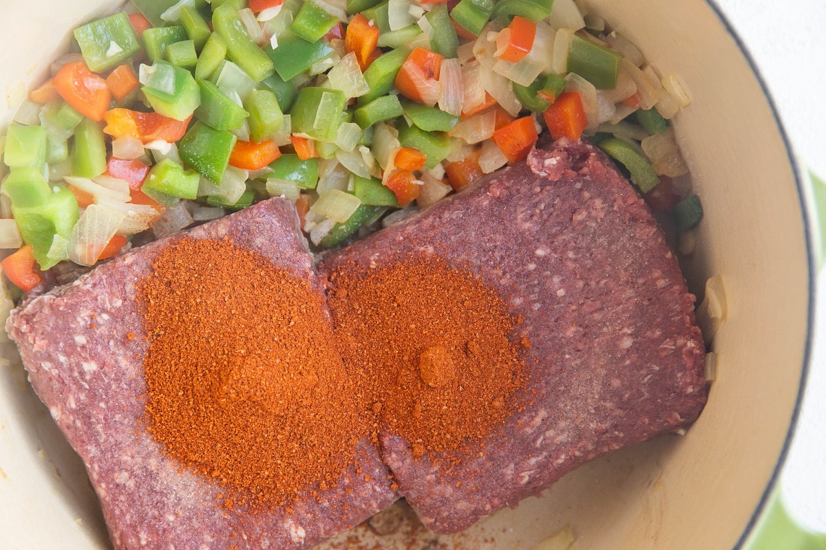 Onions, peppers, ground beef and chili powder in a large pot.