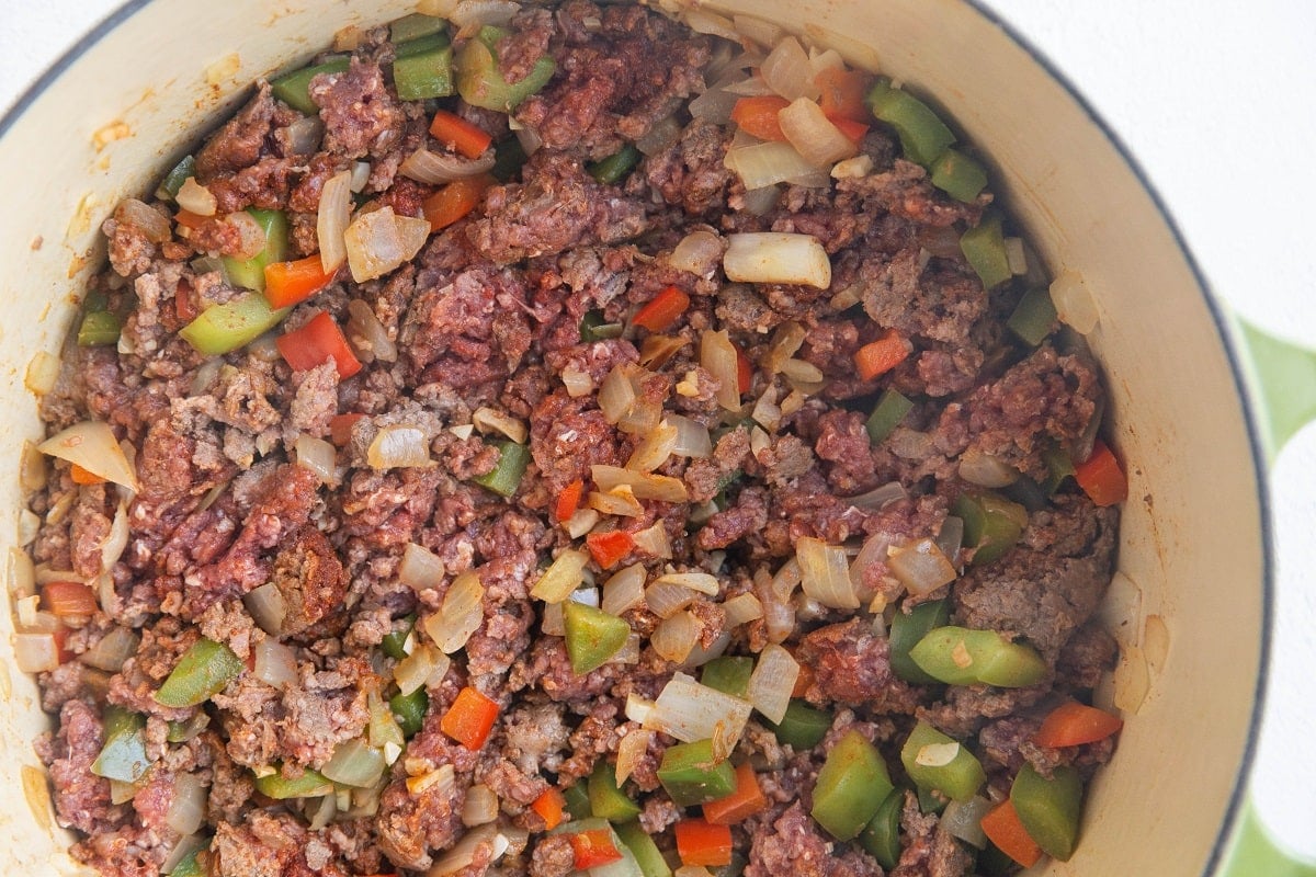 Meat, veggies and seasonings cooking in a pot to make beef chili