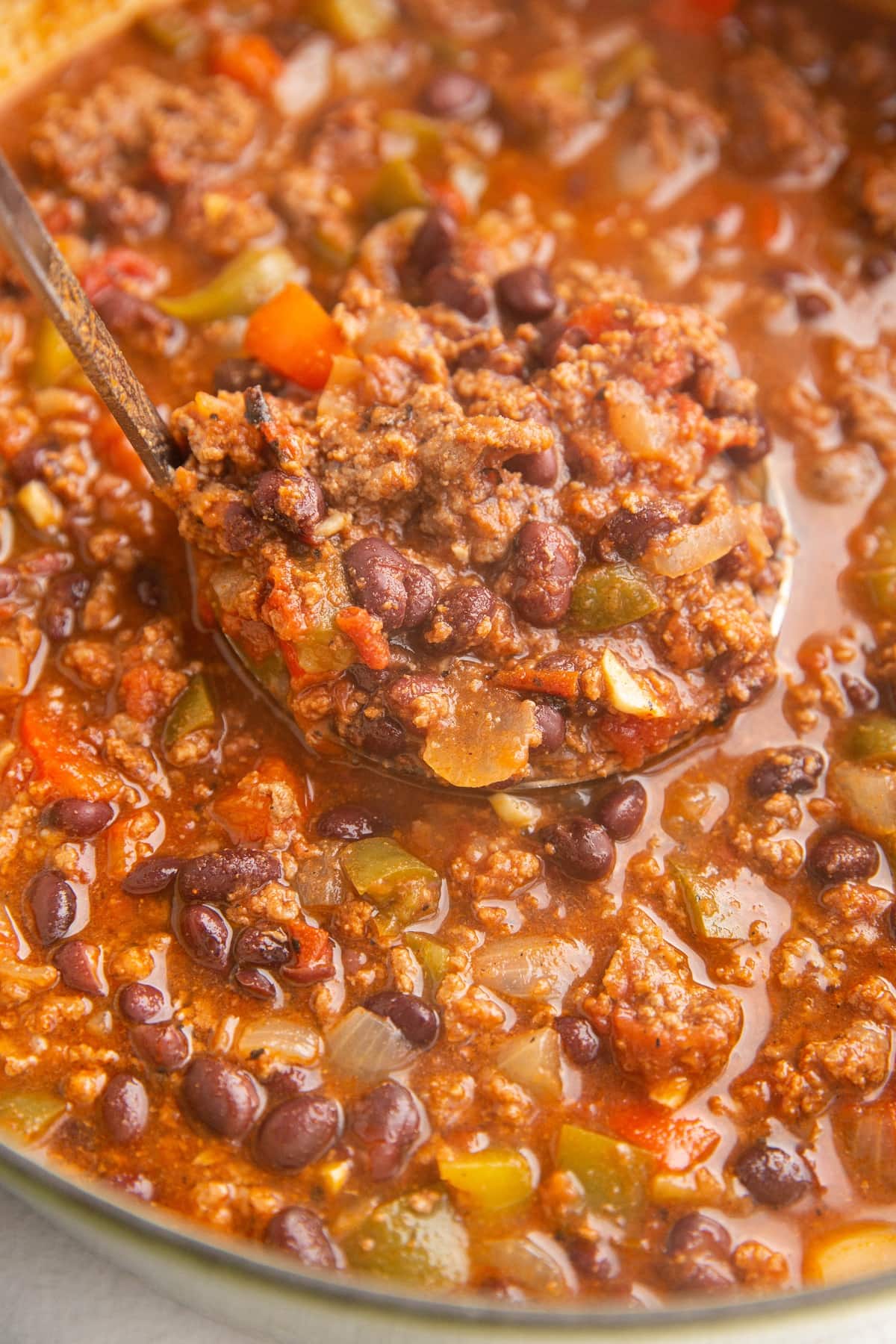 Scooping chili out of a pot to serve.