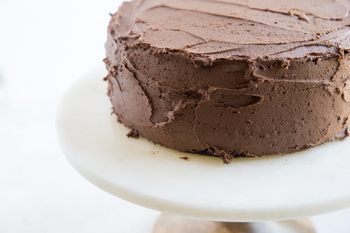Chocolate layer cake coated in a thick layer of frosting.