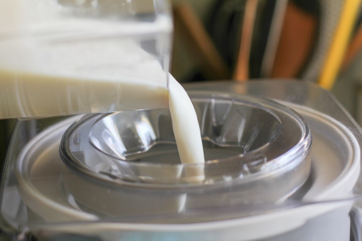 Pouring vanilla ice cream base into an ice cream maker.