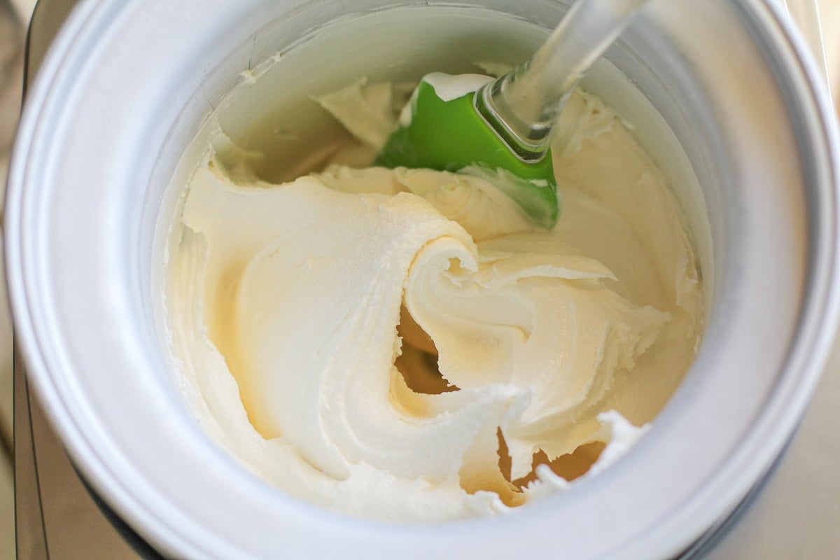 Vanilla ice cream in an ice cream maker that has just finished churning. Ready to eat for a soft serve consistency or freeze.