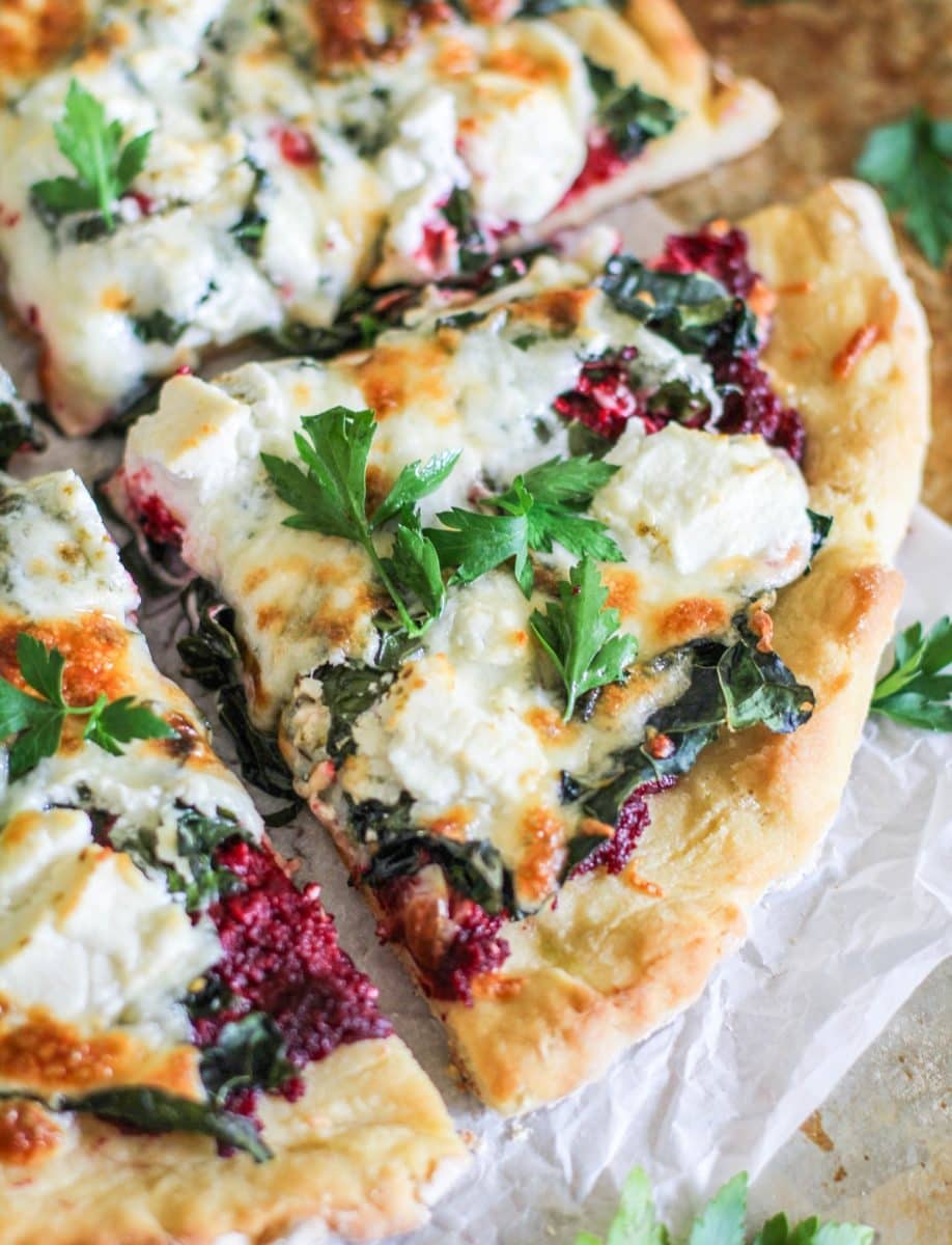 Four large slices of beet pesto pizza, fresh out of the oven.