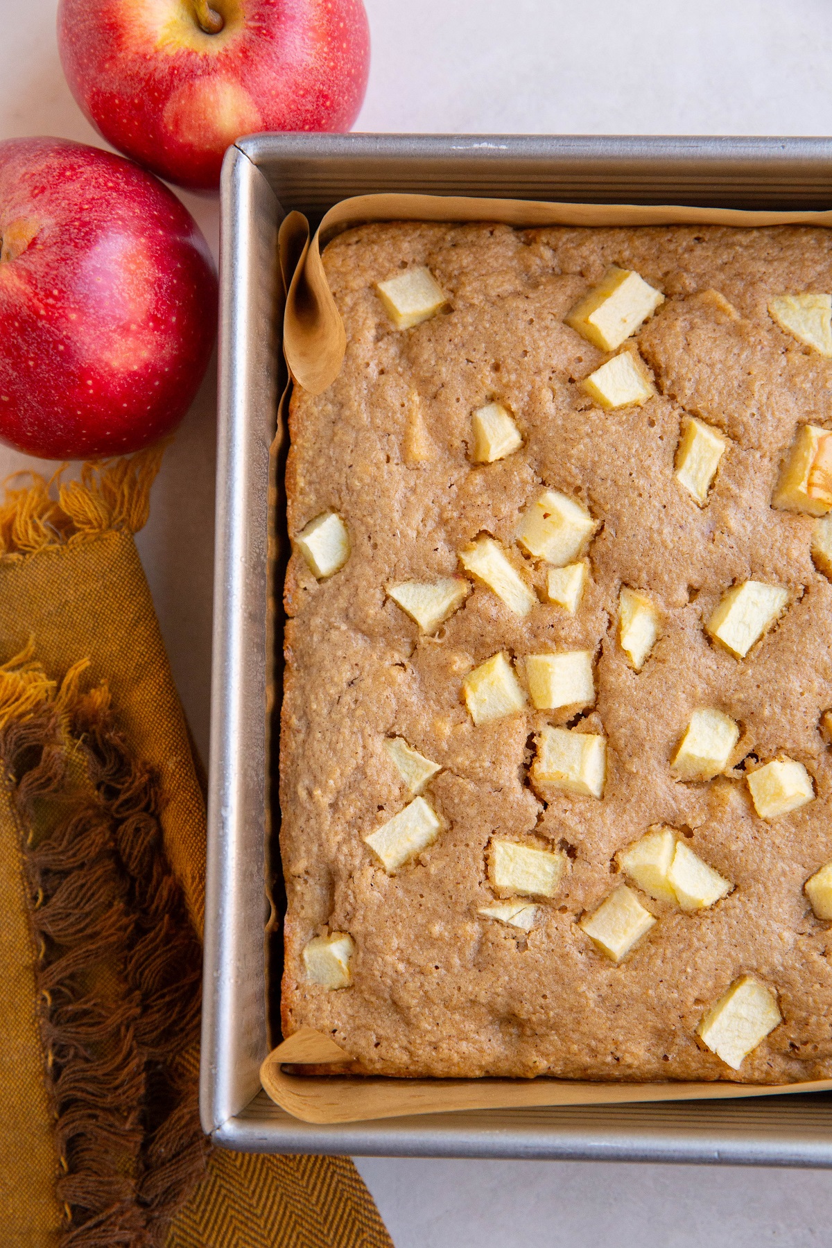 Square cake pan of apple cake, ready to be sliced and served.