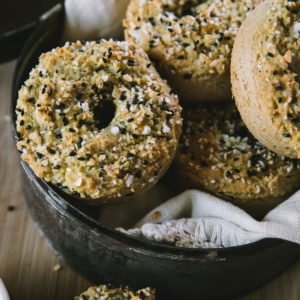Basket full of almond flour bagels with a linen inside, ready to eat.