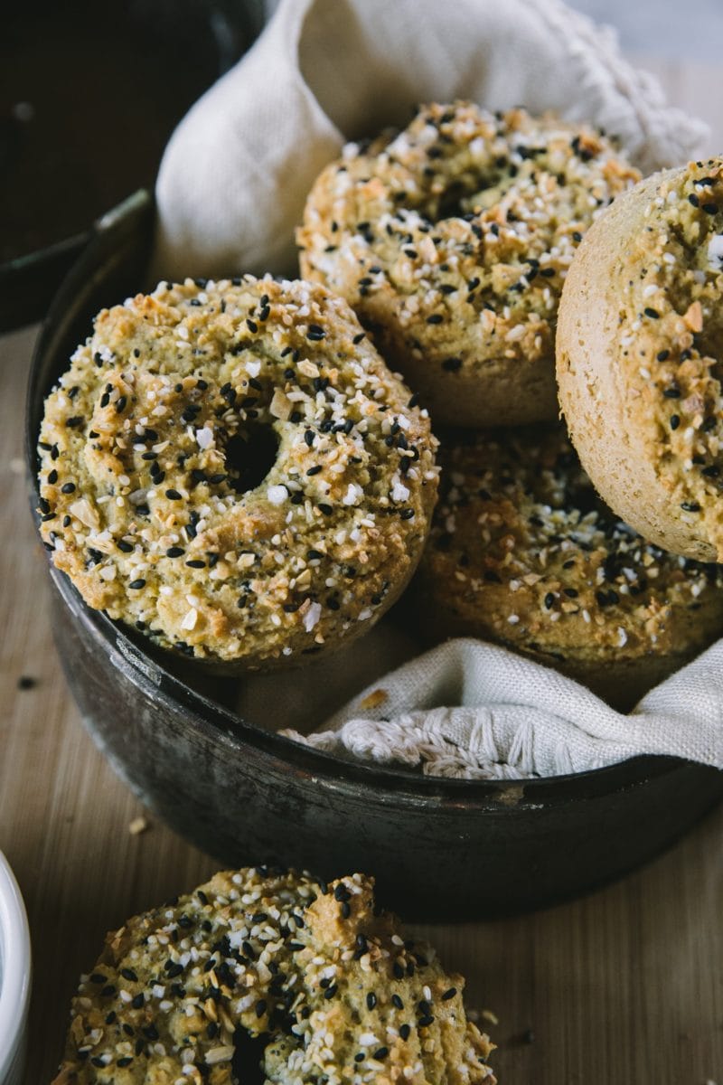 Basket full of almond flour bagels with a linen inside, ready to eat.