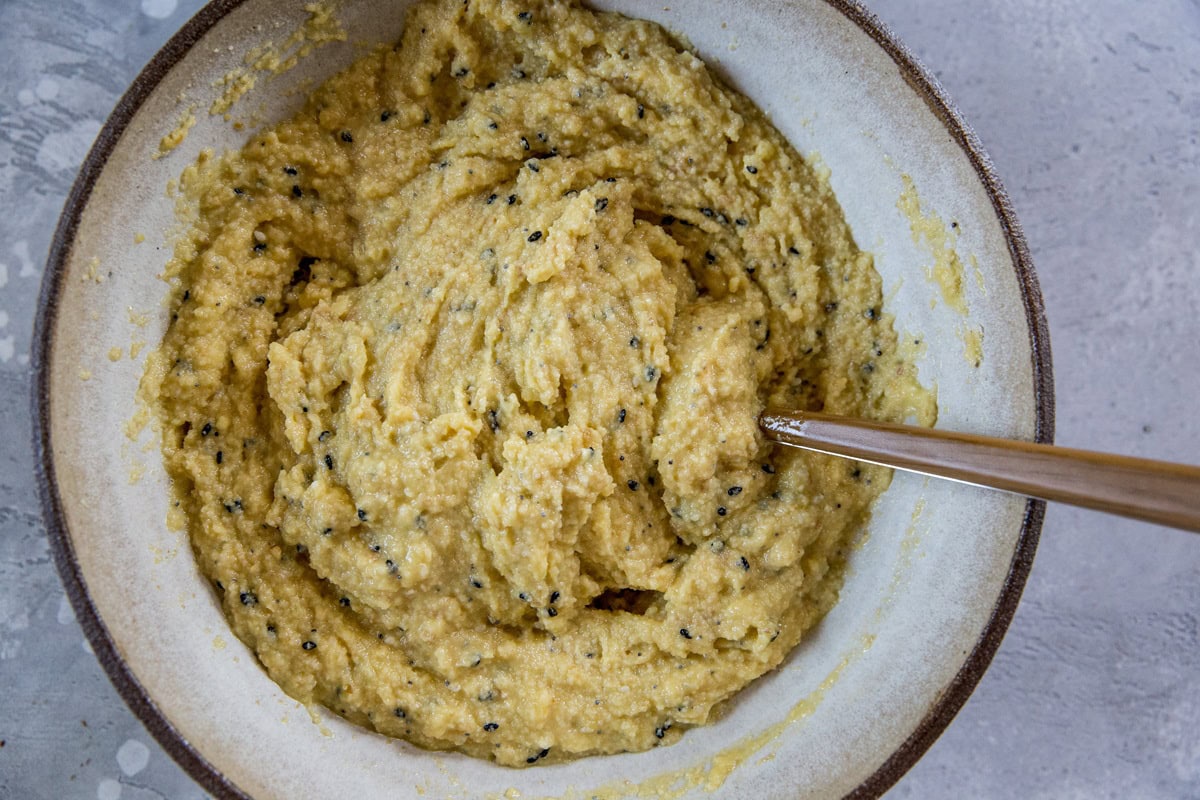 Everything bagel batter in a bowl, stirred up and ready to bake