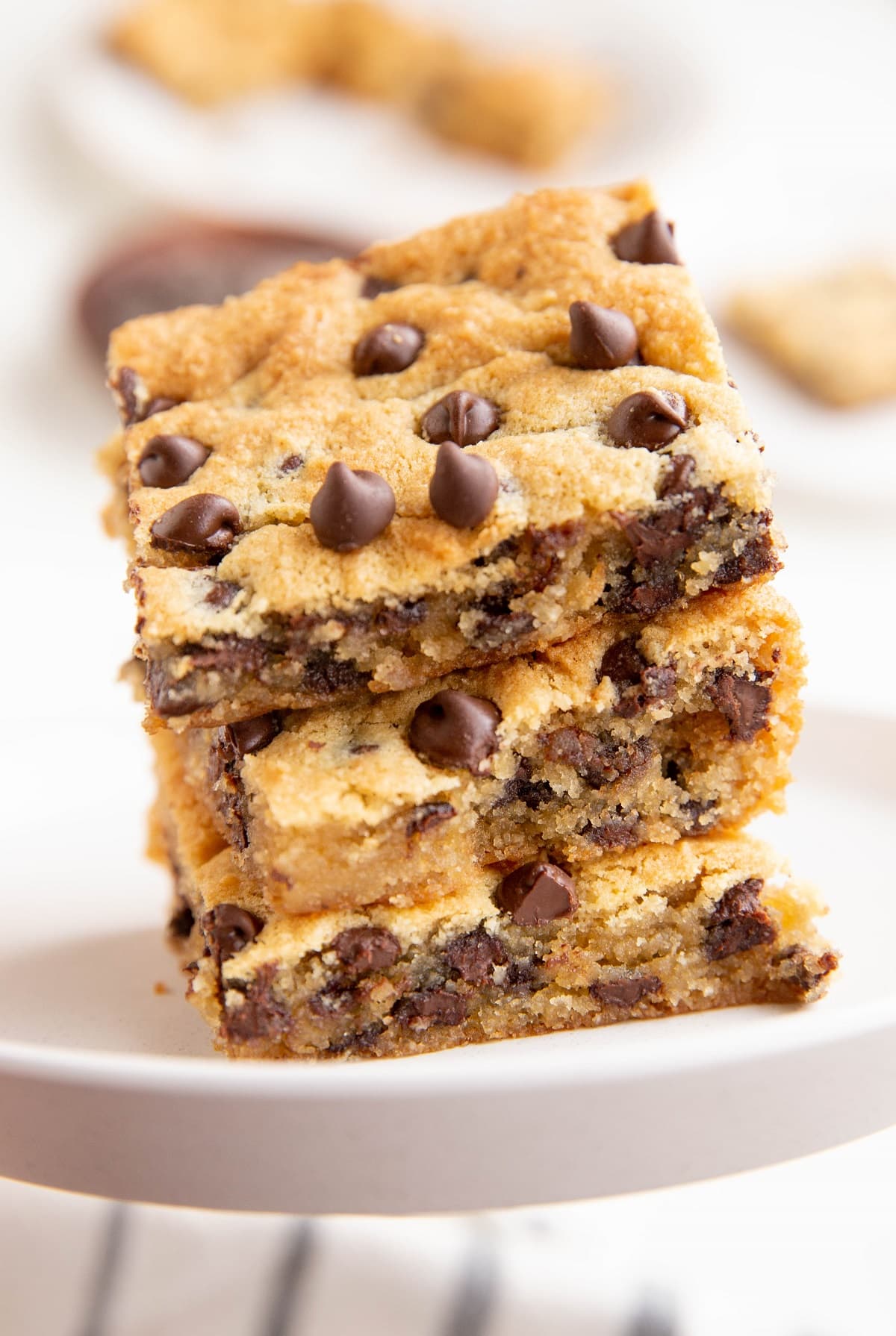 Three cookie bars stacked on top of each other on a white plate.