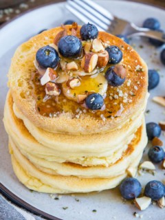 Almond flour pancakes on a plate with blueberries and banana, ready to eat