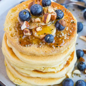 Almond flour pancakes on a plate with blueberries and banana, ready to eat