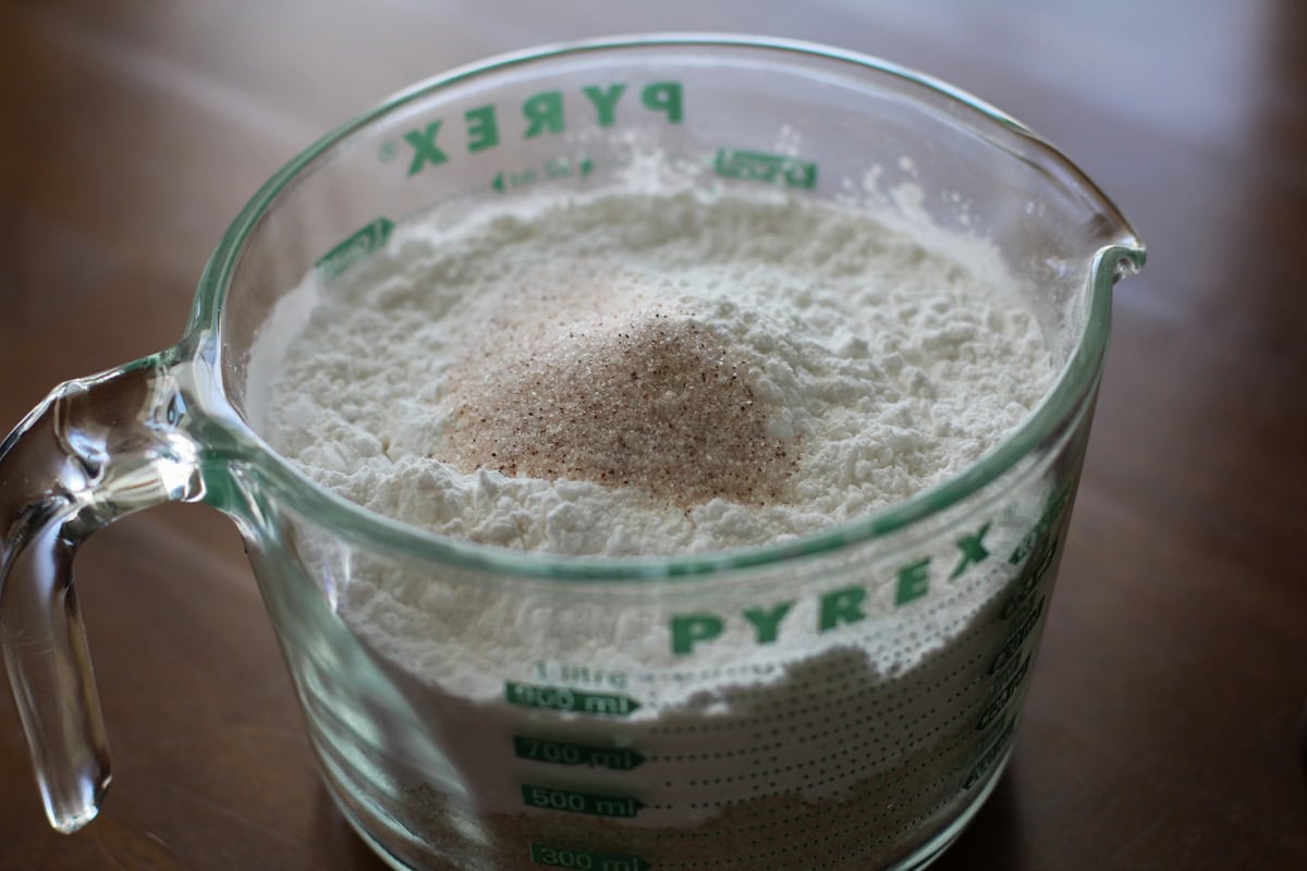 Large measuring cup full of almond flour, tapioca flour, and sea salt to be mixed up.