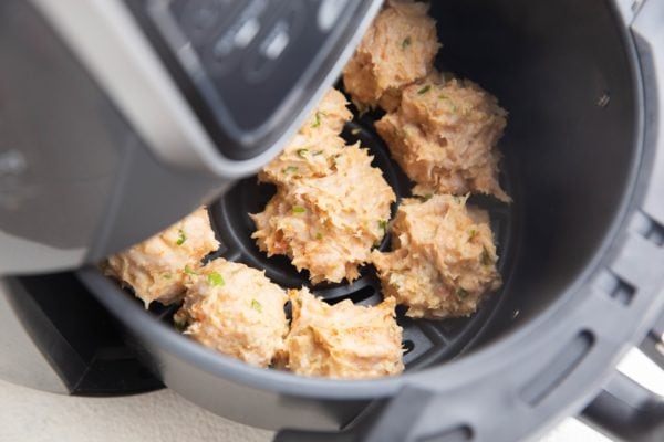 Raw meatballs in an air fryer, ready to air fry.