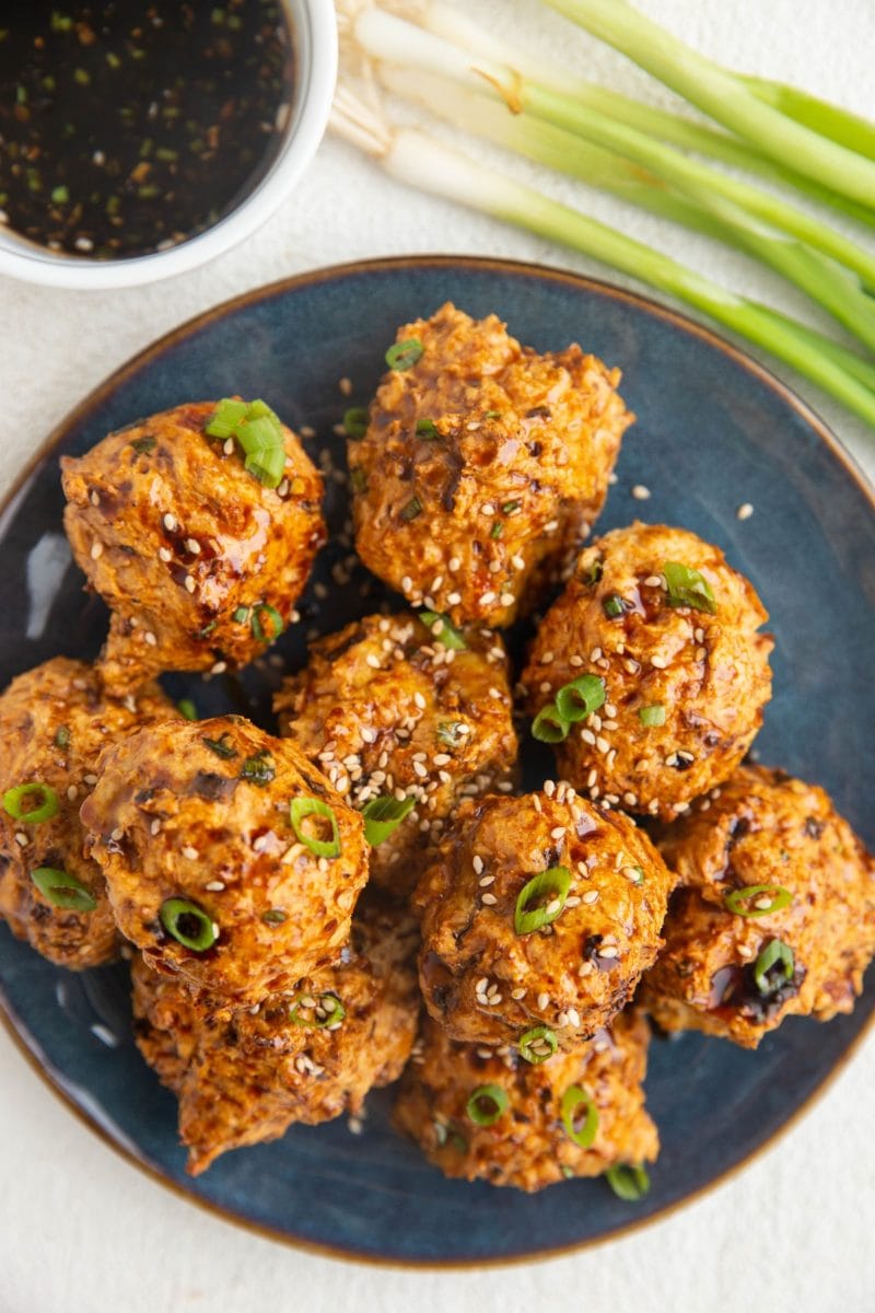 Blue plate with Asian turkey meatballs on top, ready to serve.