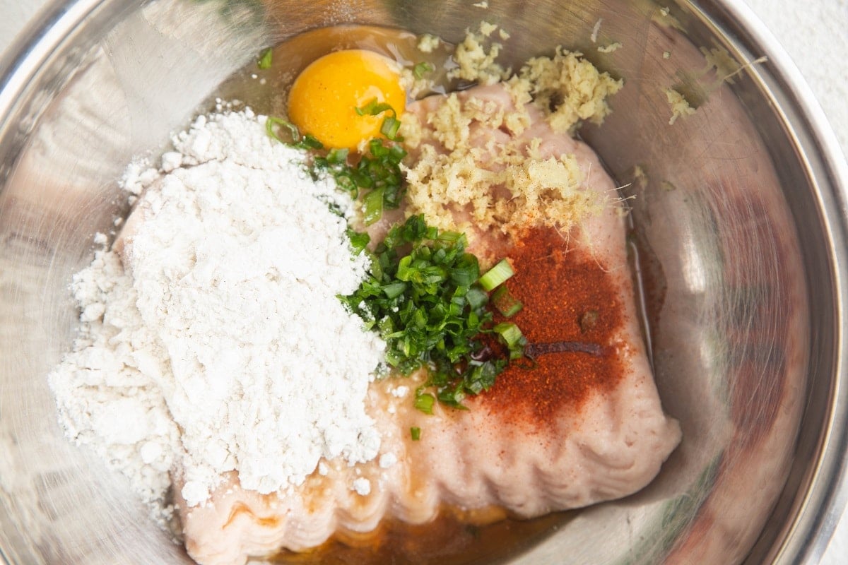 Ingredients for turkey meatballs in a mixing bowl to make turkey meatball mixture for air fryer meatballs.