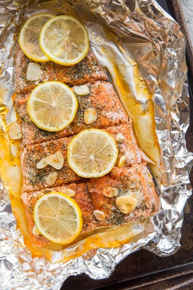Salmon Baked in Foil with garlic and lemon sitting on a baking sheet, ready to serve.