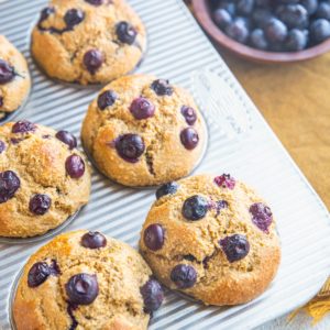Muffin tray with blueberry banana muffins inside, fresh out of the oven.