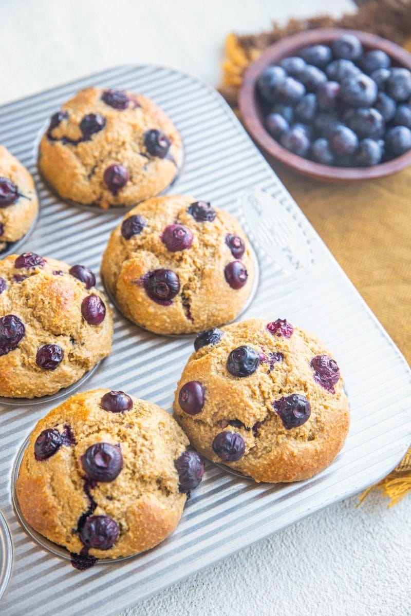 Muffin tray with blueberry banana muffins inside, fresh out of the oven.