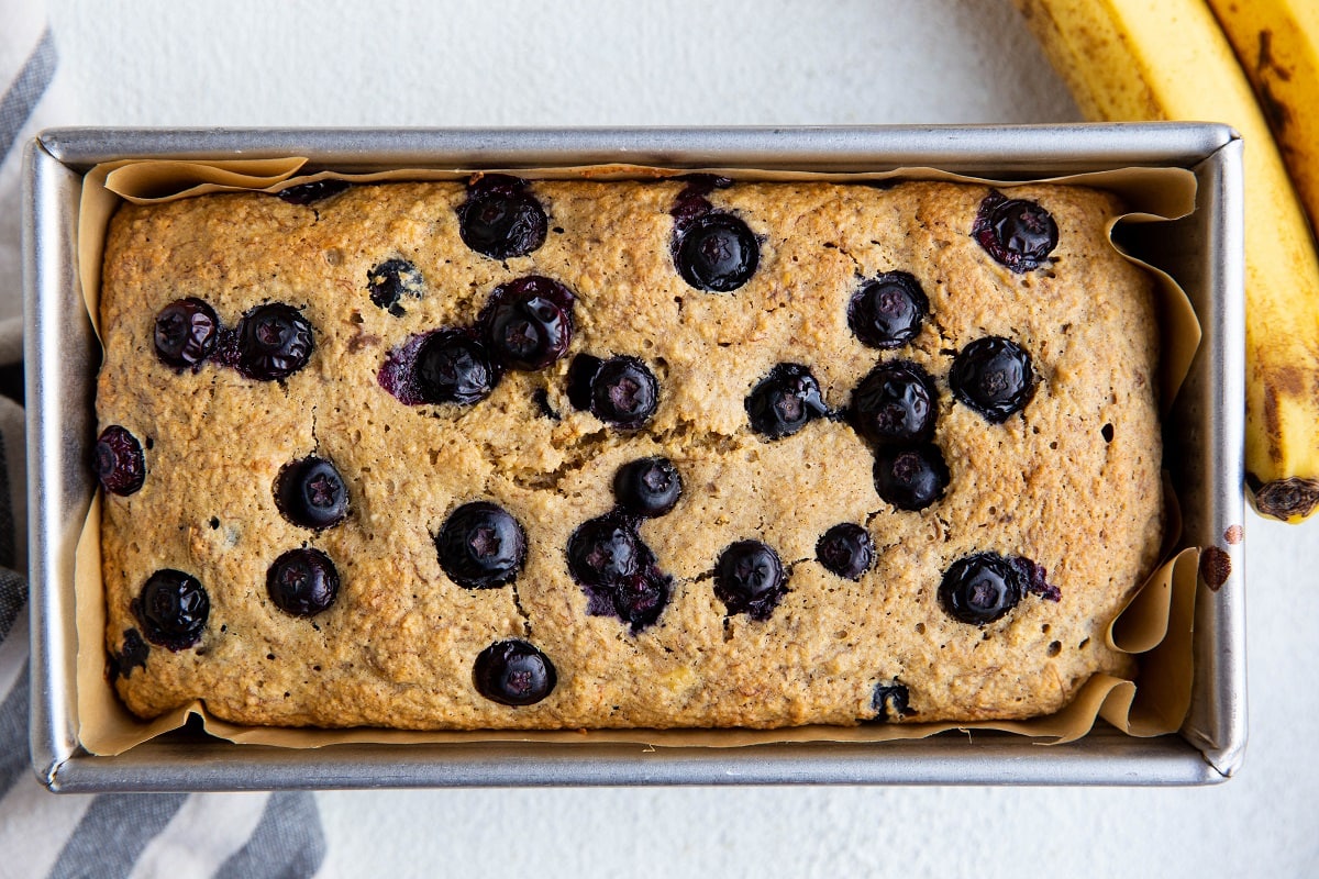 Freshly baked blueberry banana bread in a loaf pan fresh out of the oven.