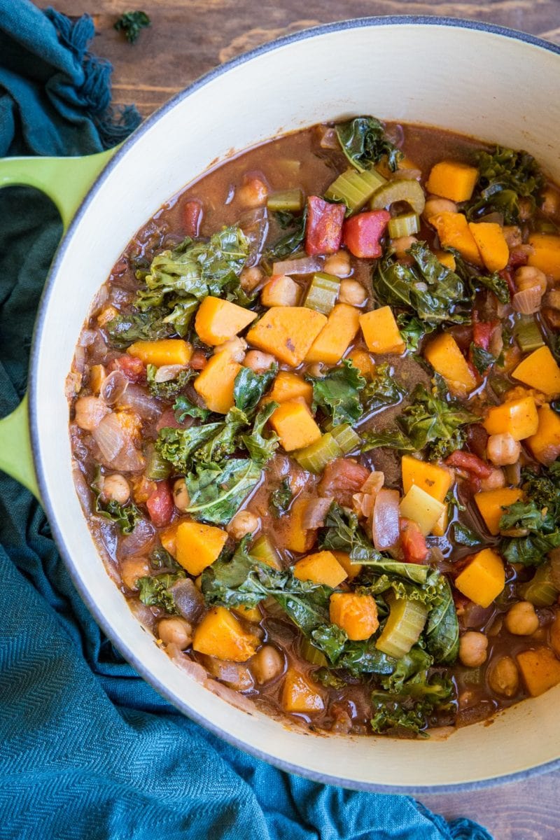 Butternut Squash and Chickpea Chili with Kale in a large pot with a blue napkin to the side, ready to serve.