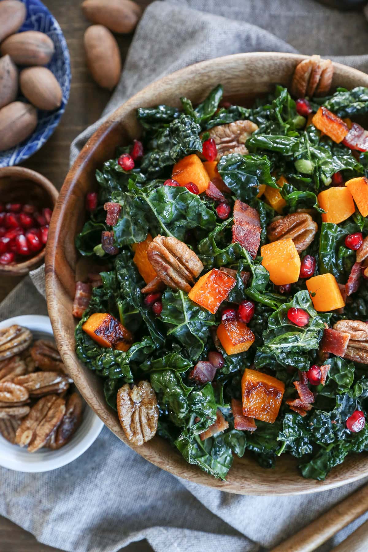 Big kale salad with butternut squash in a bowl with pecans and pomegranate seeds