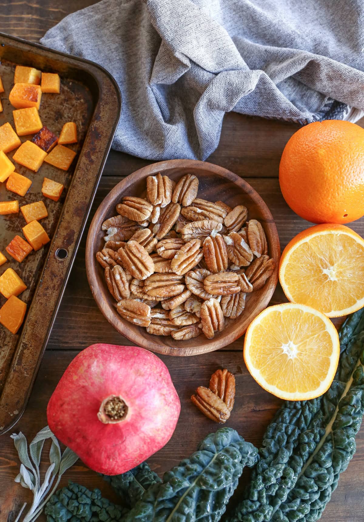 Prep shot for roasted butternut squash kale salad with ingredients on a wooden background.