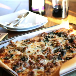Cauliflower Pizza Crust pizza on a baking sheet with cheese, sausage, sauce, and more. Ready to serve.