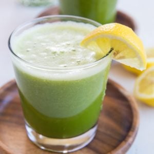Two glasses of celery juice with slices of lemon.